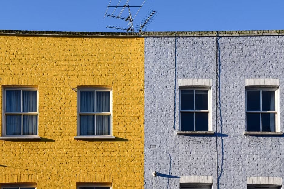 Yellow and lilac painted terraced house fronts in London